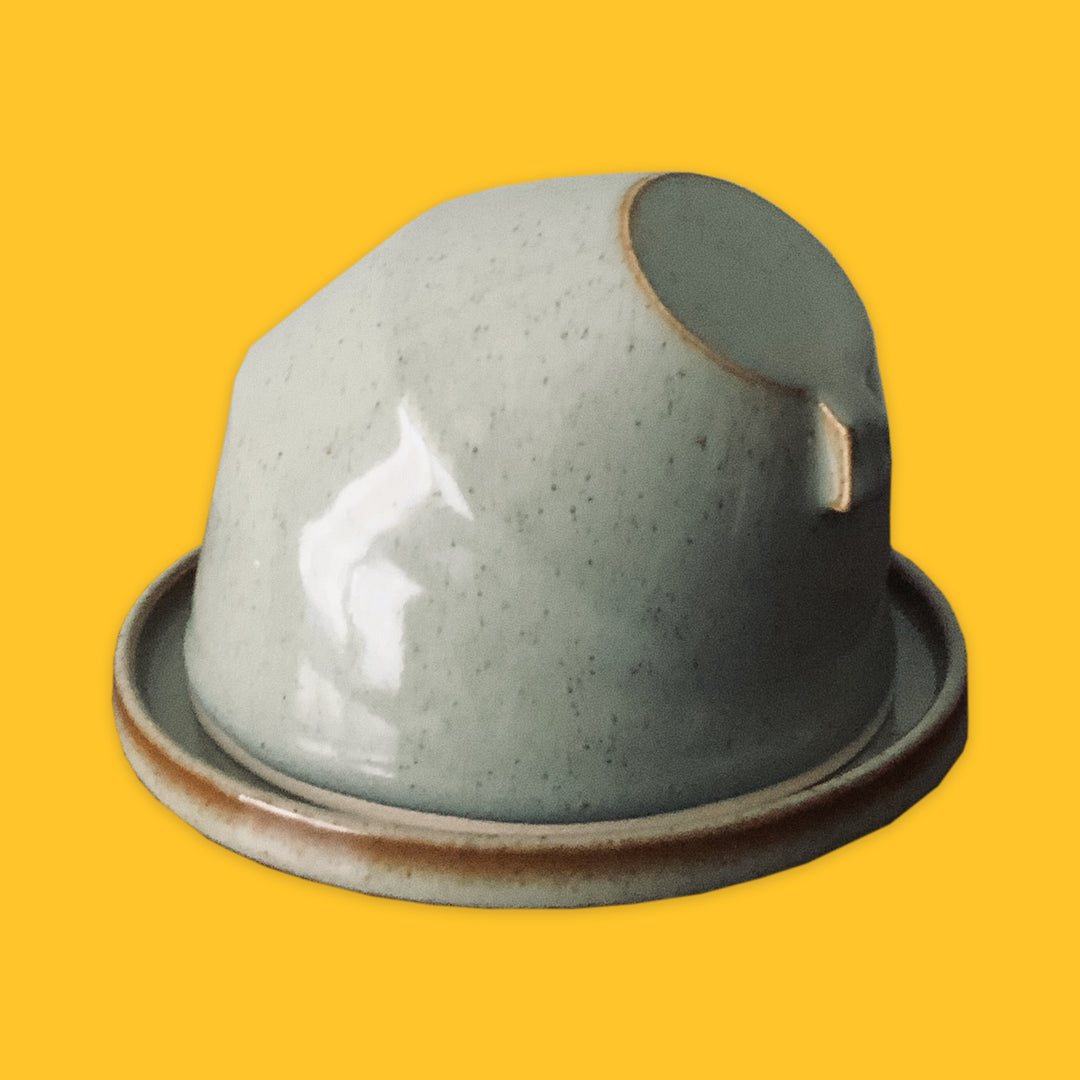 Sage Ceramic butter dish with a lid on a yellow background