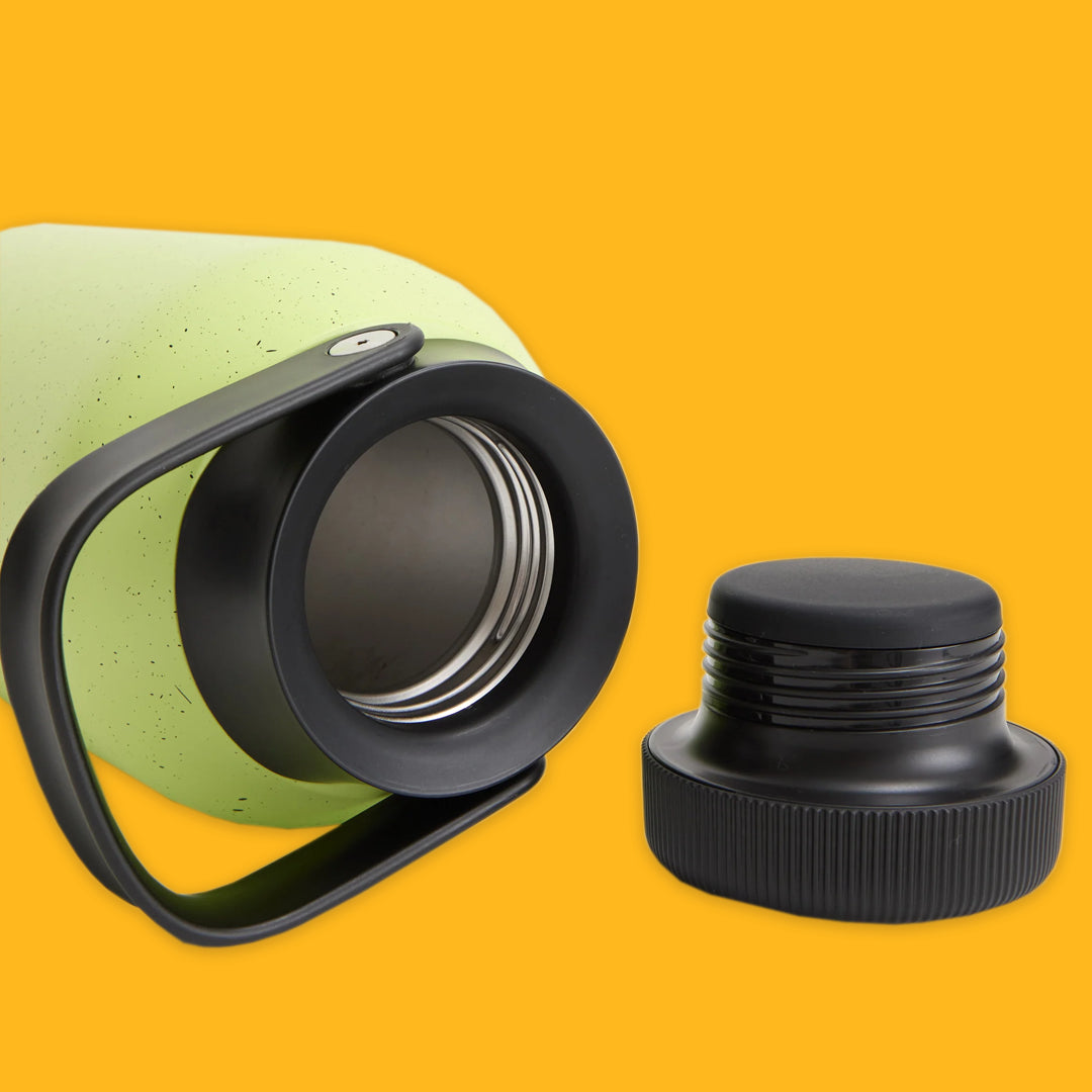 Green thermos with black lid on a yellow background
