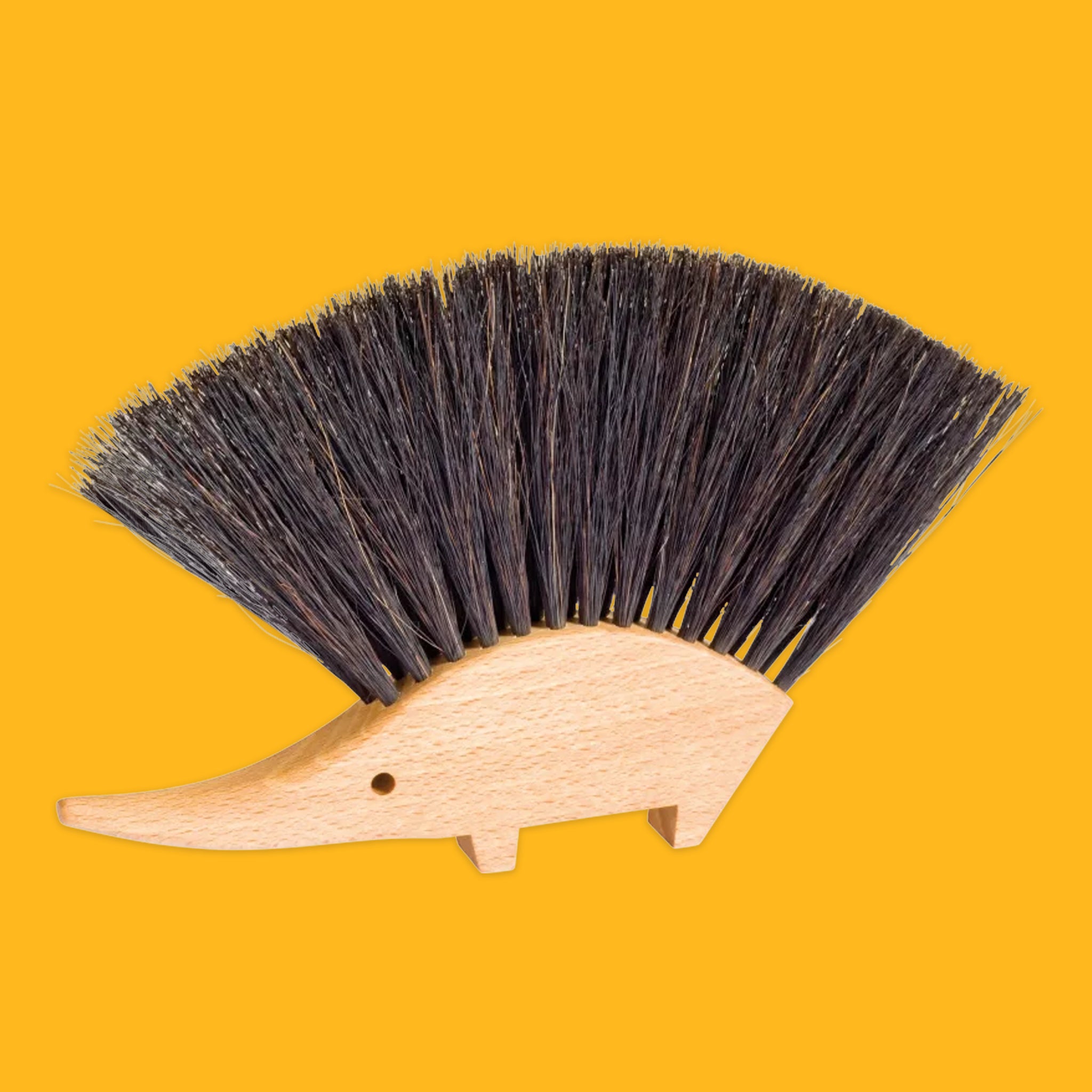 Hedgehog-shaped brush with bristles on a yellow background
