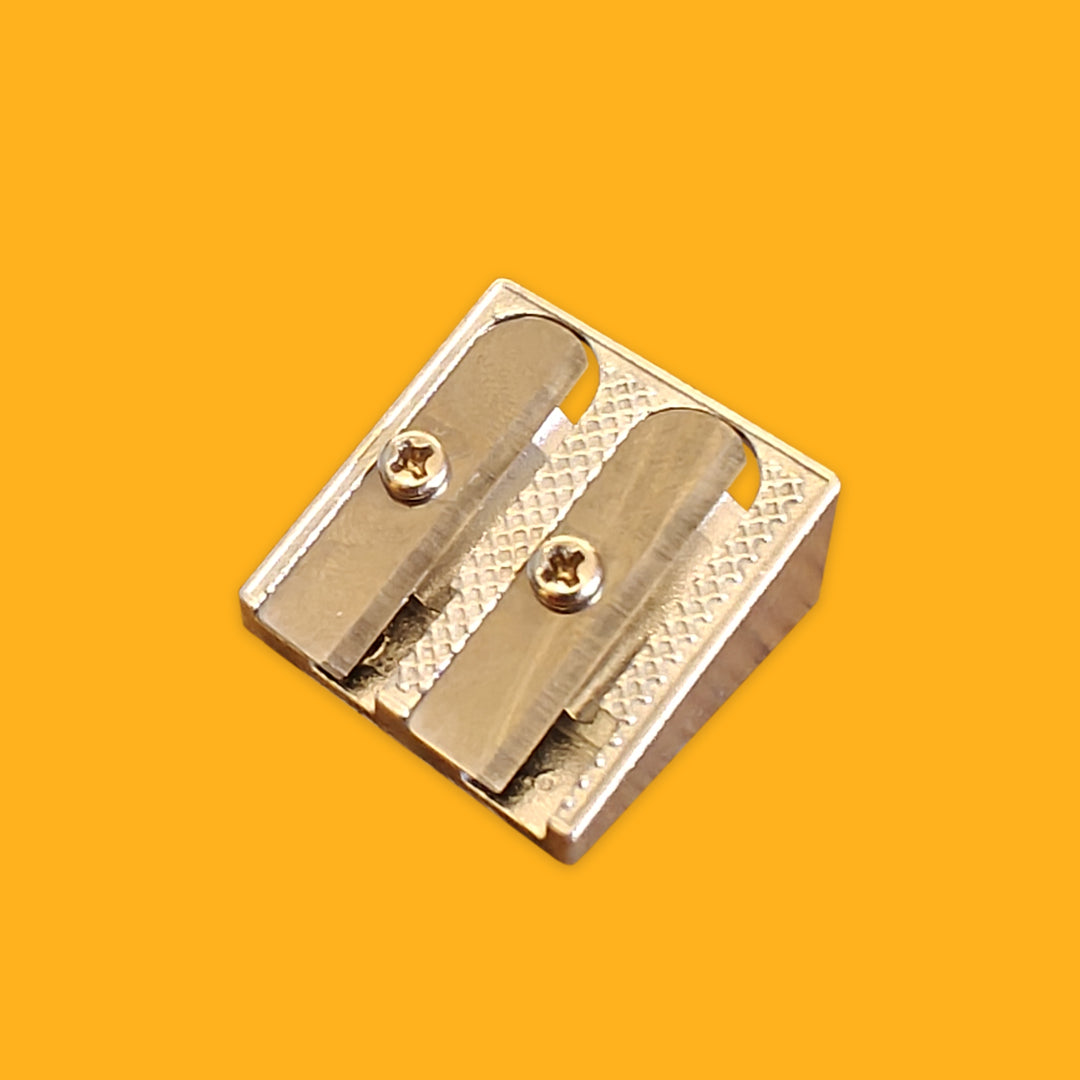 Metallic pencil sharpener on a yellow background