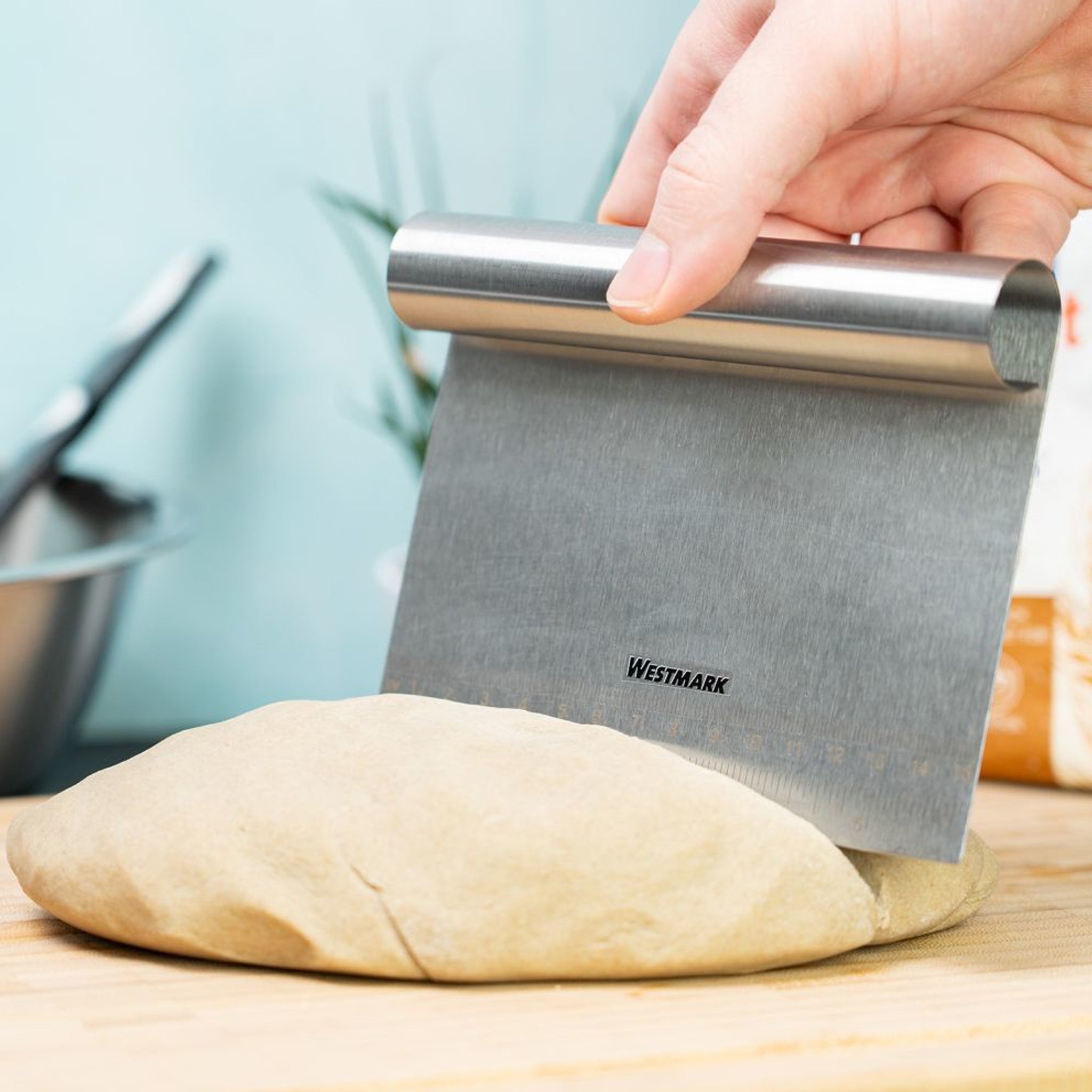 Dough scraper cutting through dough