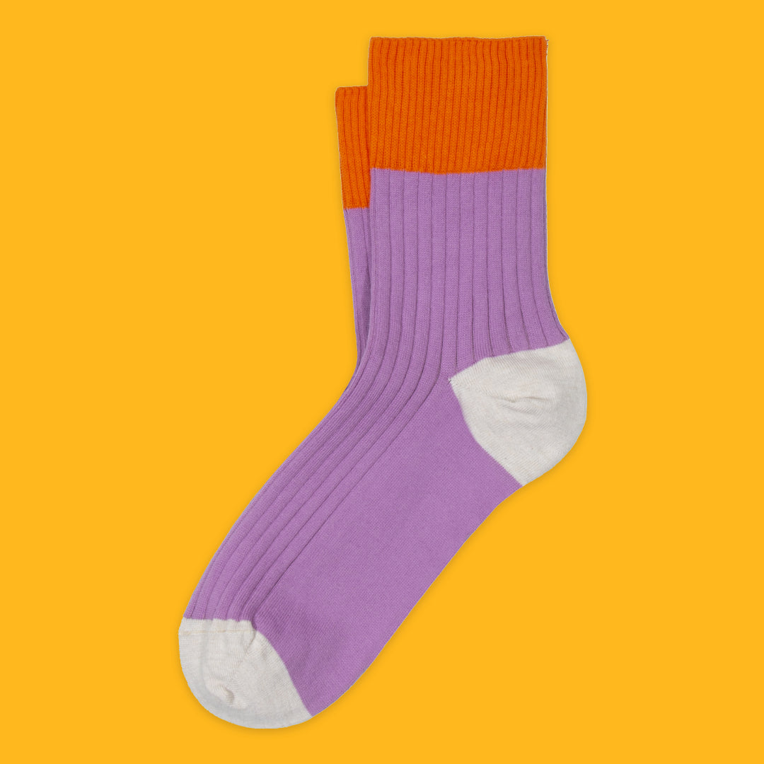 Purple sock with orange top on a yellow background