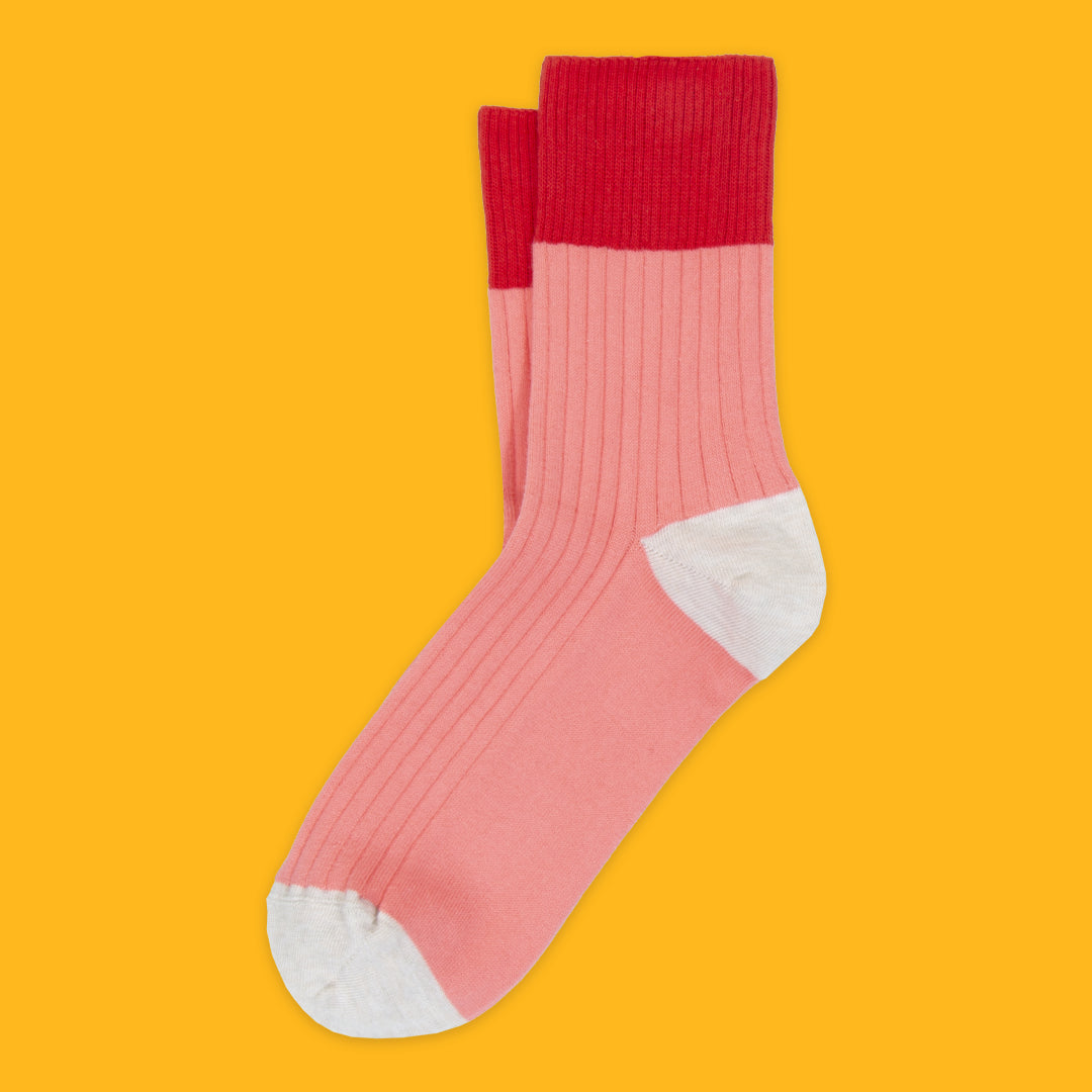 Pink sock with red top on a yellow background