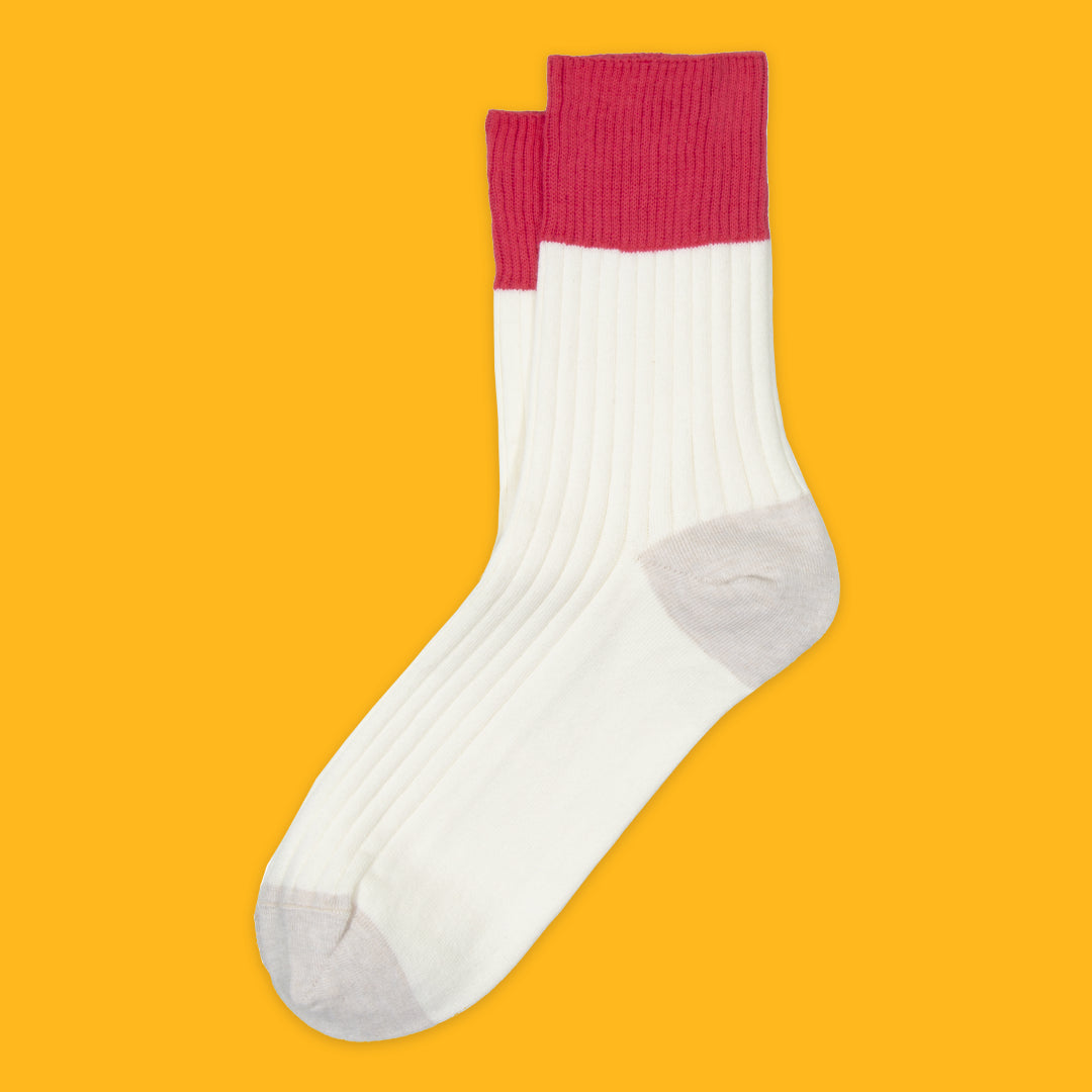 White sock with pink cuff on a yellow background