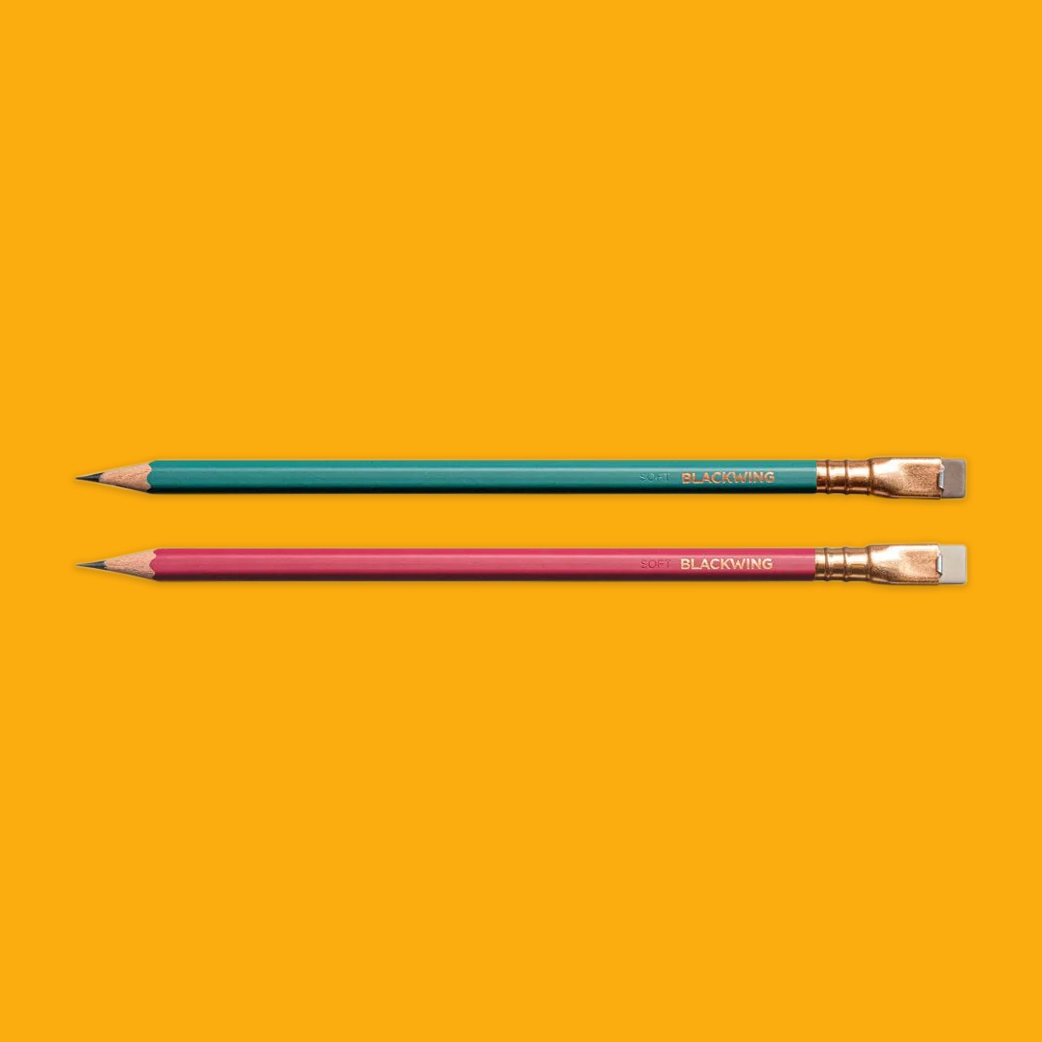 Two pencils, one green and one red, on a yellow background