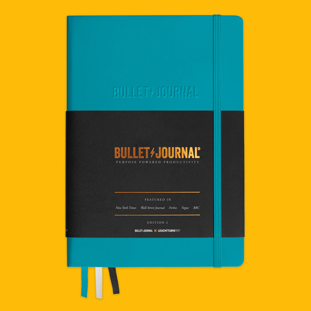 Bullet Journal in Turquoise on a yellow background