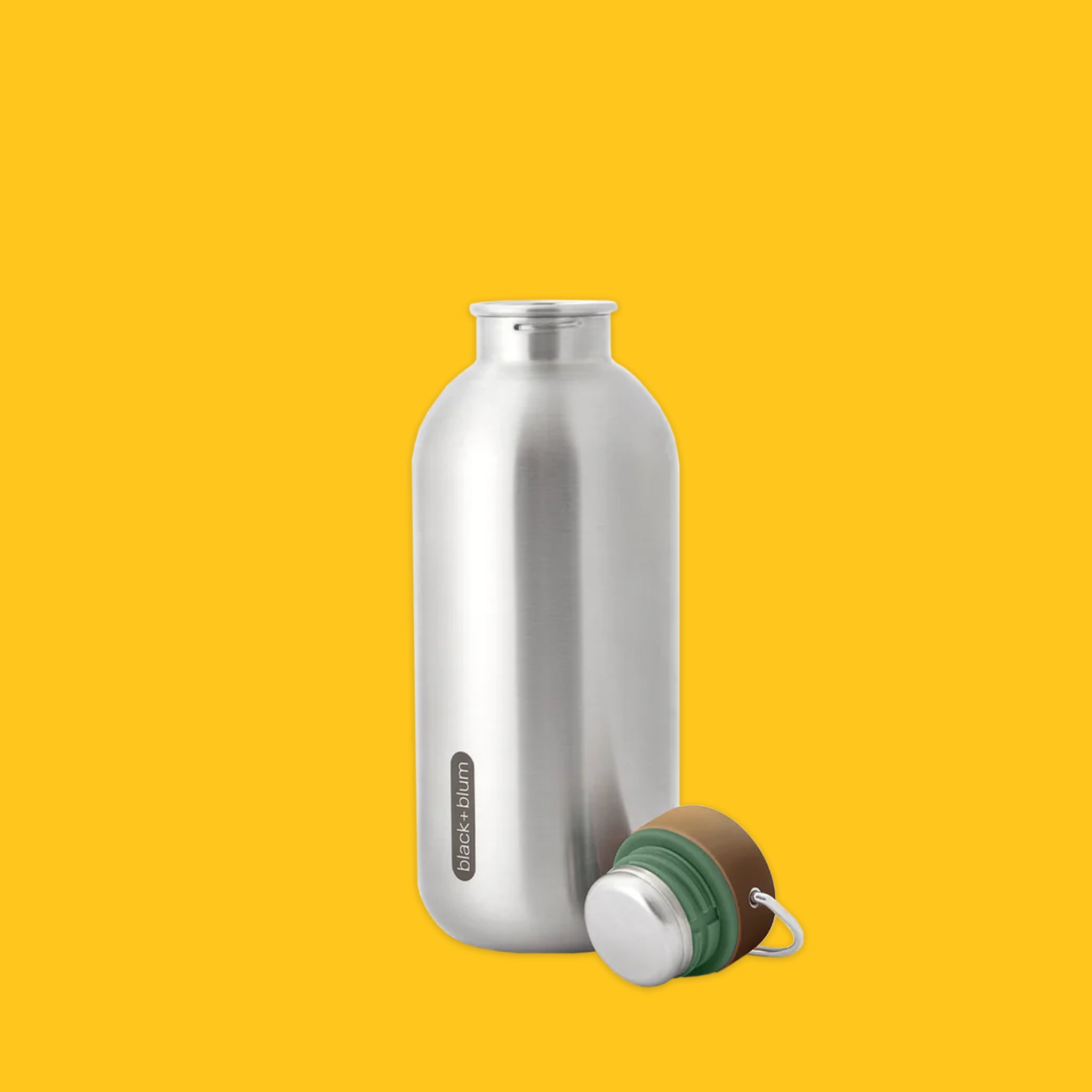 Steel bottle with top off on a yellow background