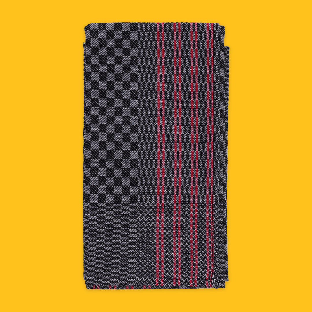 Folded Tea Towel in Black with Red Stripe on yellow background