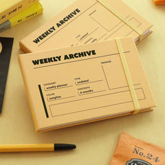 Iconic Weekly Planner in Sunglow displayed on a table