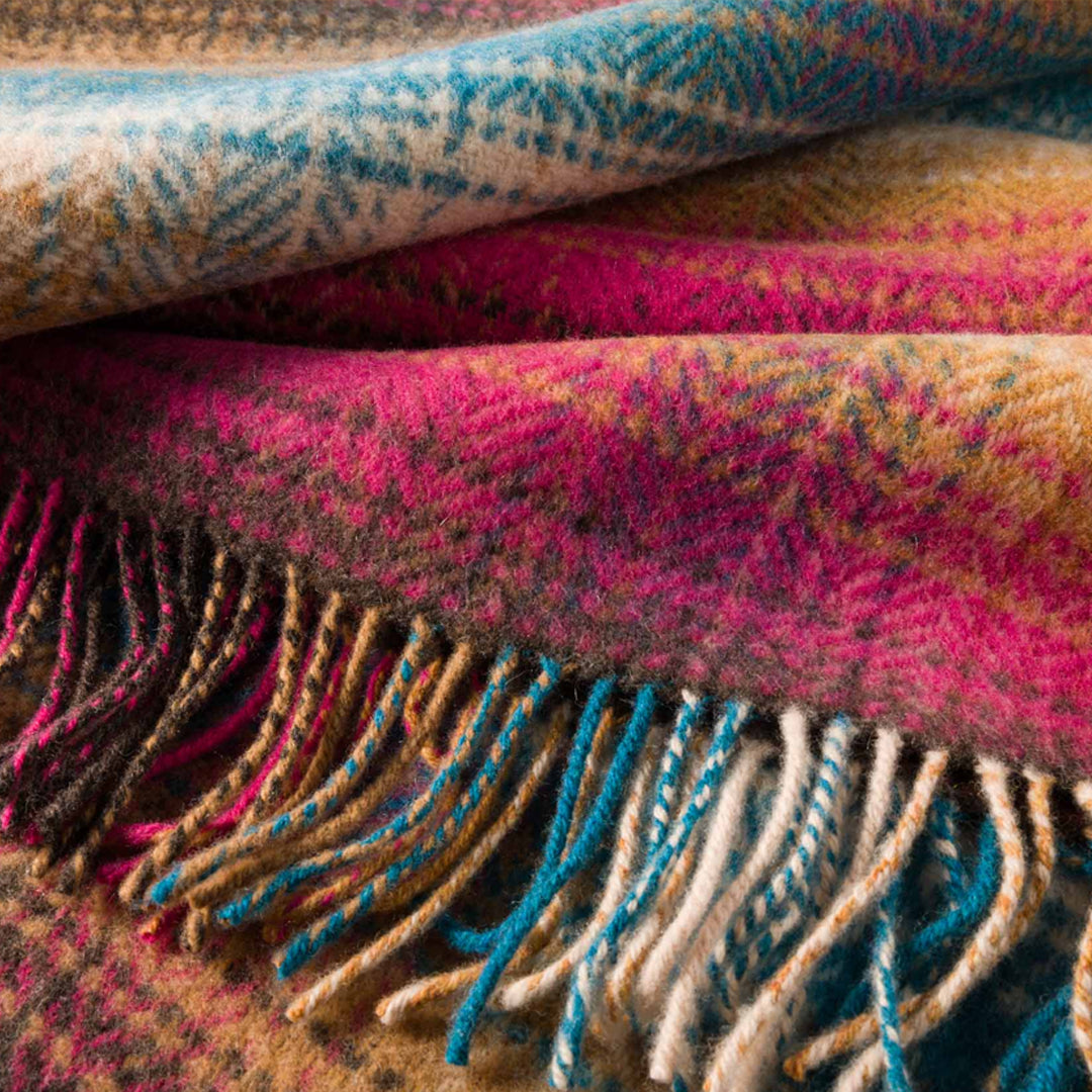 Stack of colourful patterned blankets with fringes