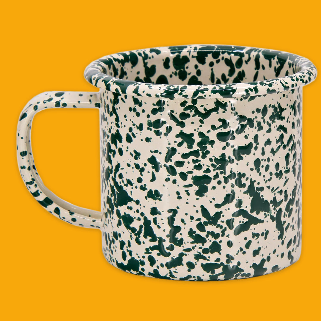 Splatter green and cream mug on a yellow background