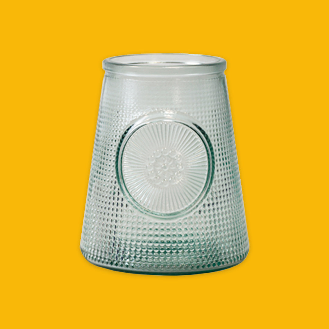 Clear textured glass vase on a yellow background