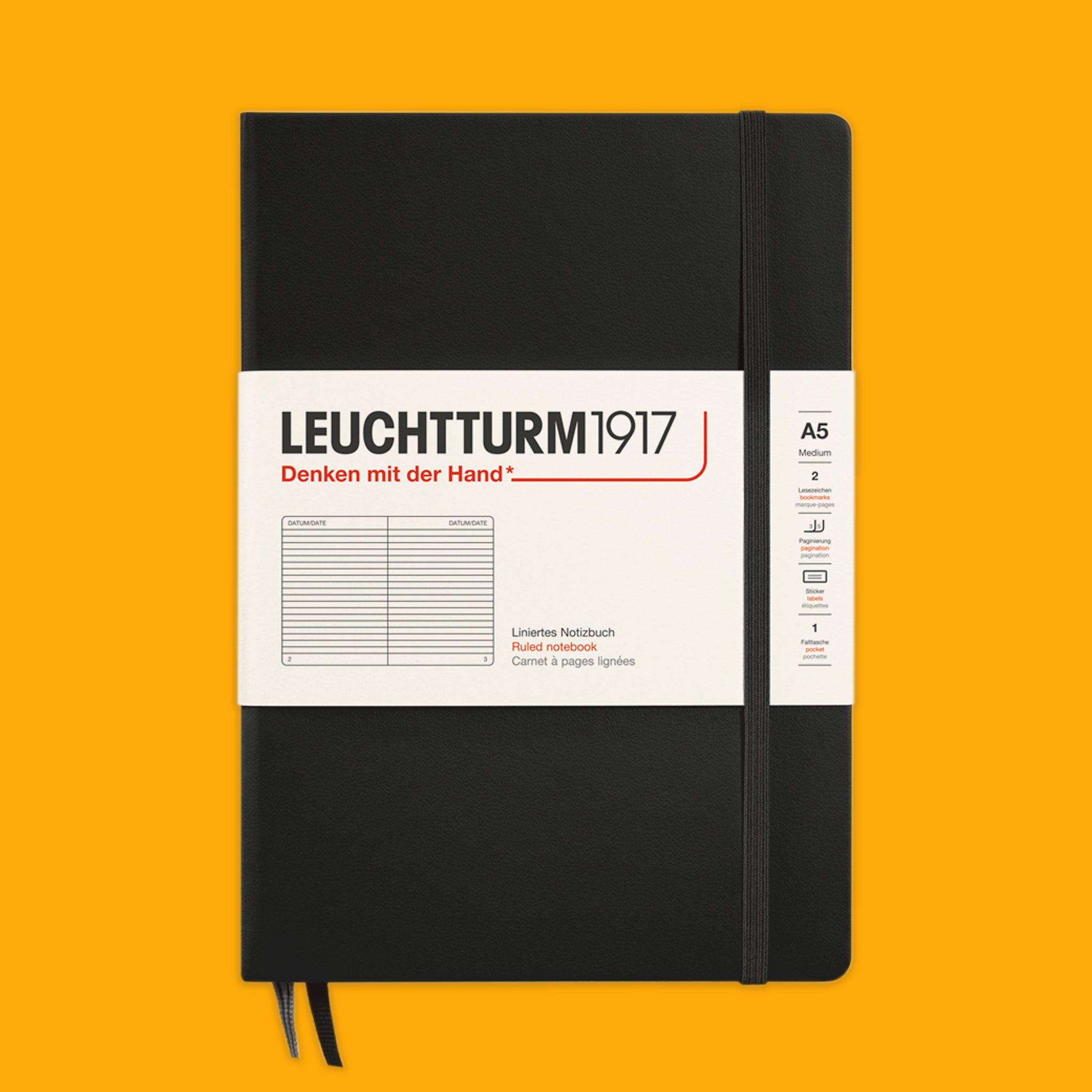 Black notebook with white label on an orange background