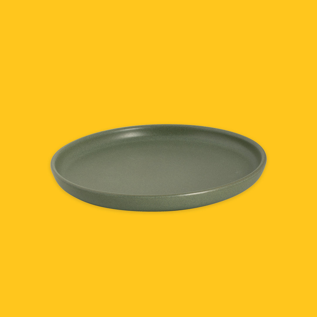 Green ceramic plate on a yellow background