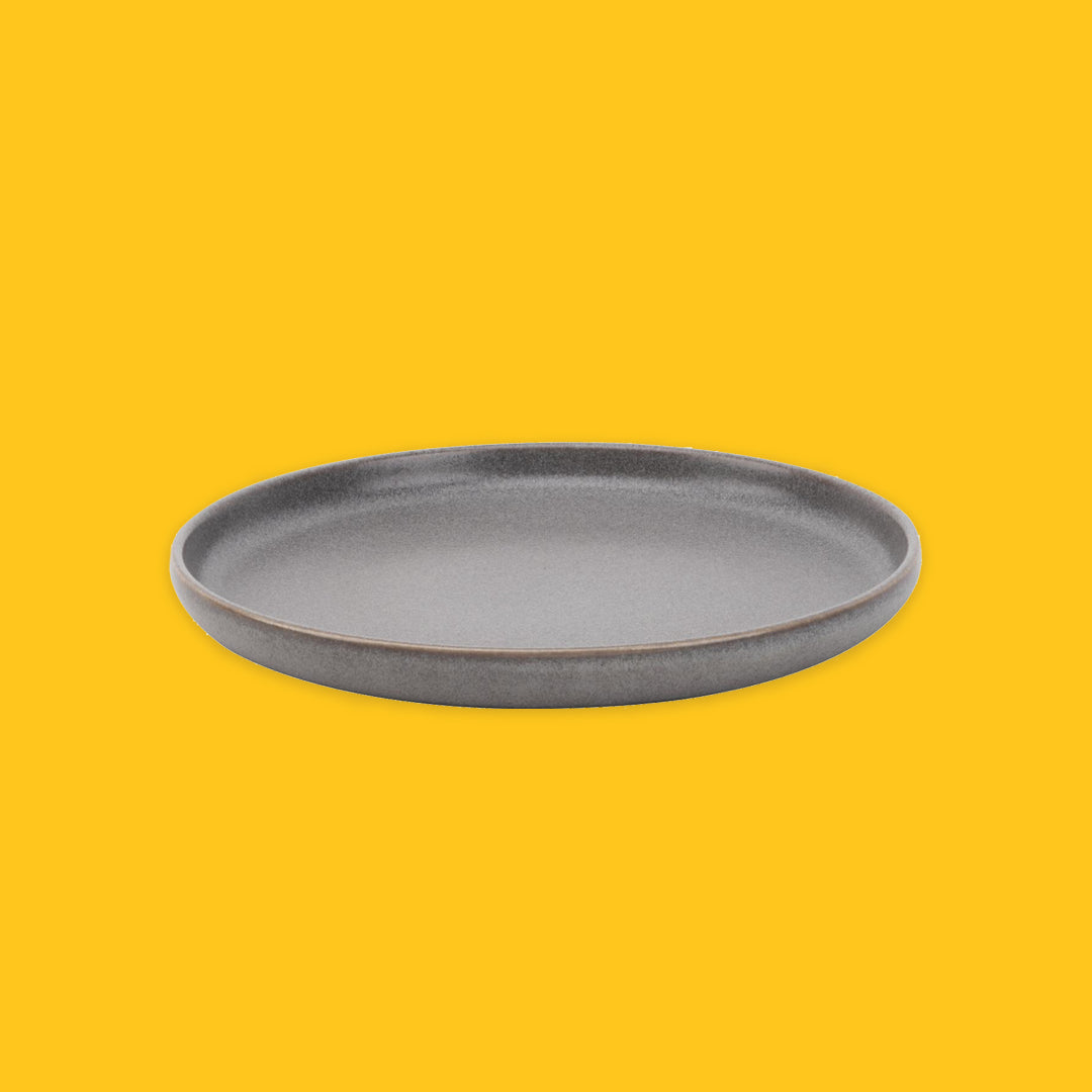 Grey ceramic plate on a yellow background