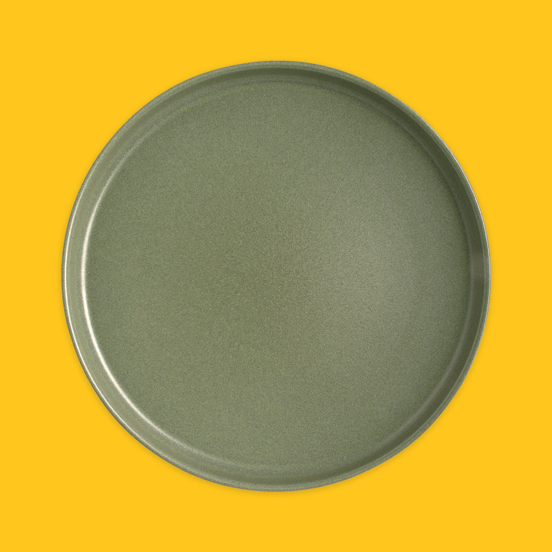 Green round plate on a yellow background