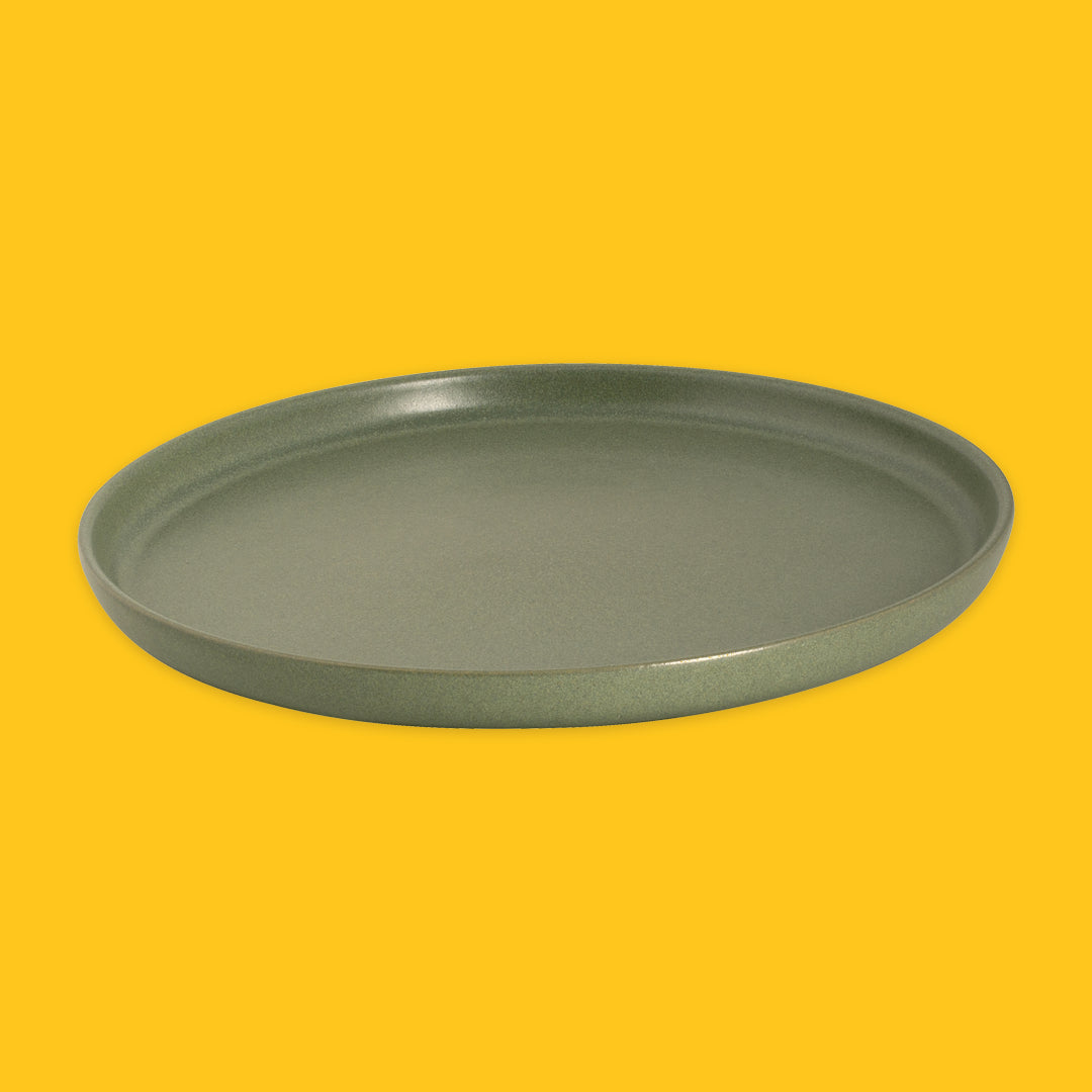 Green round plate on a yellow background