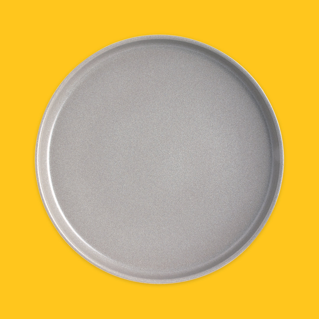 Grey round plate on a yellow background