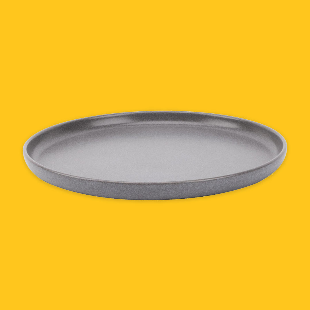 Grey round tray on a yellow background