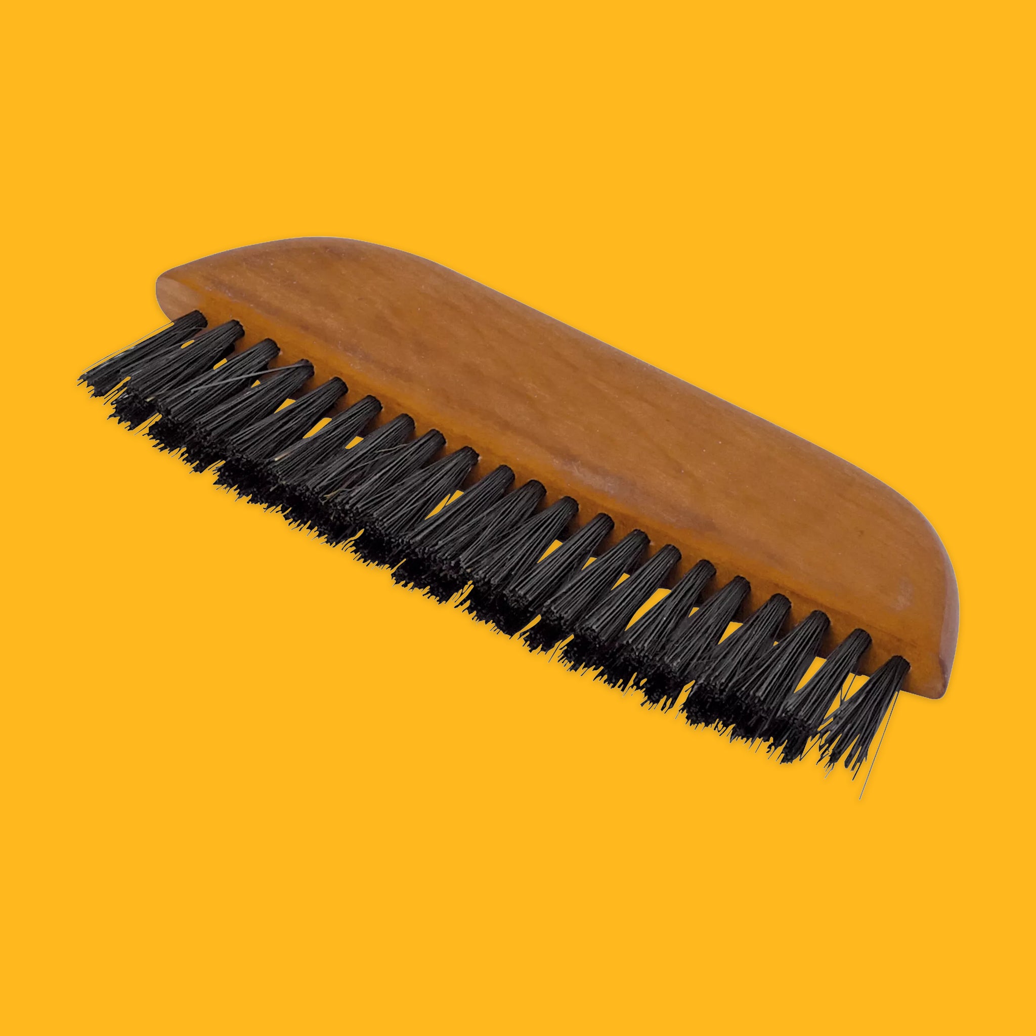 Brown and black pocket clothes brush on a yellow background