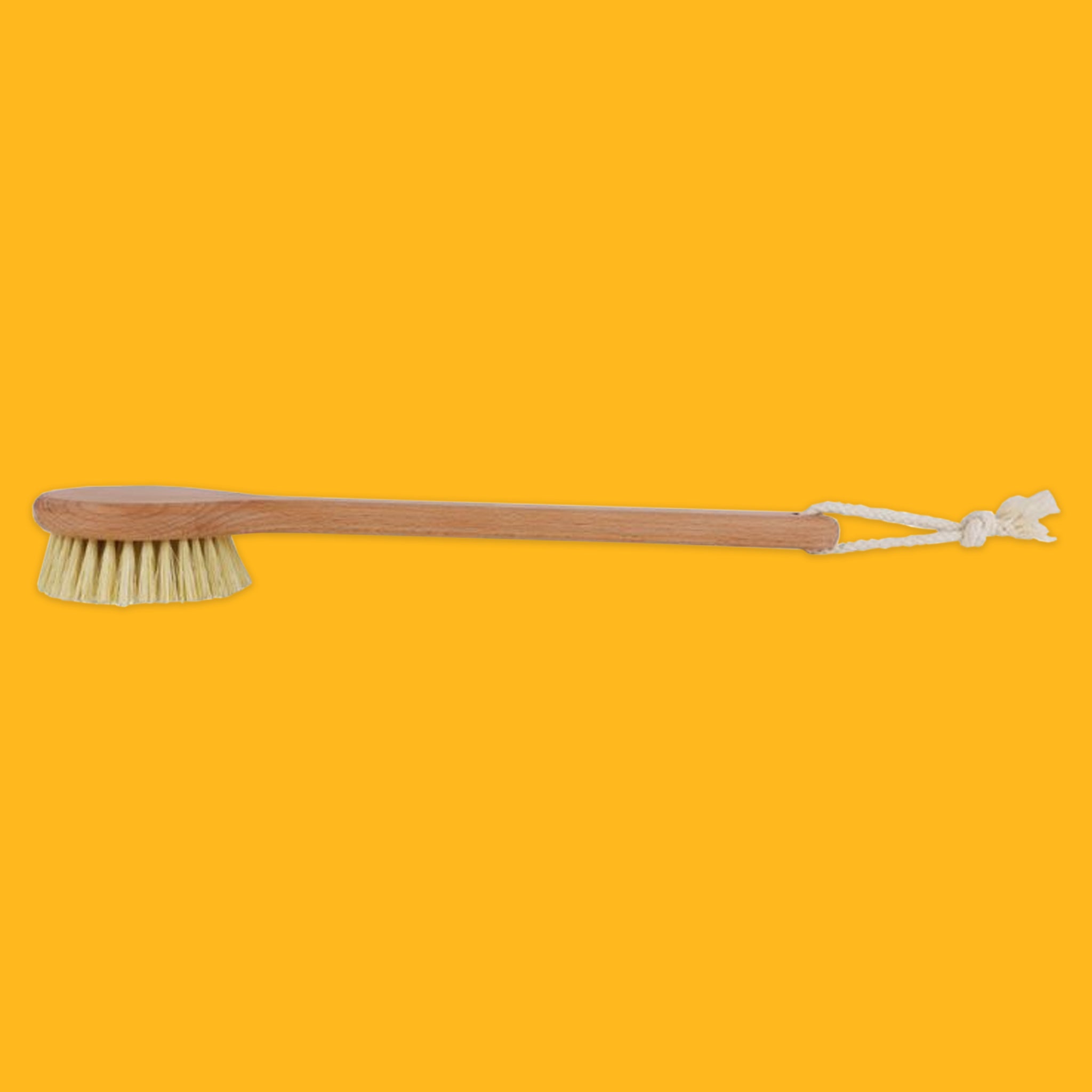 Long wooden bath brush with bristle head on a yellow background