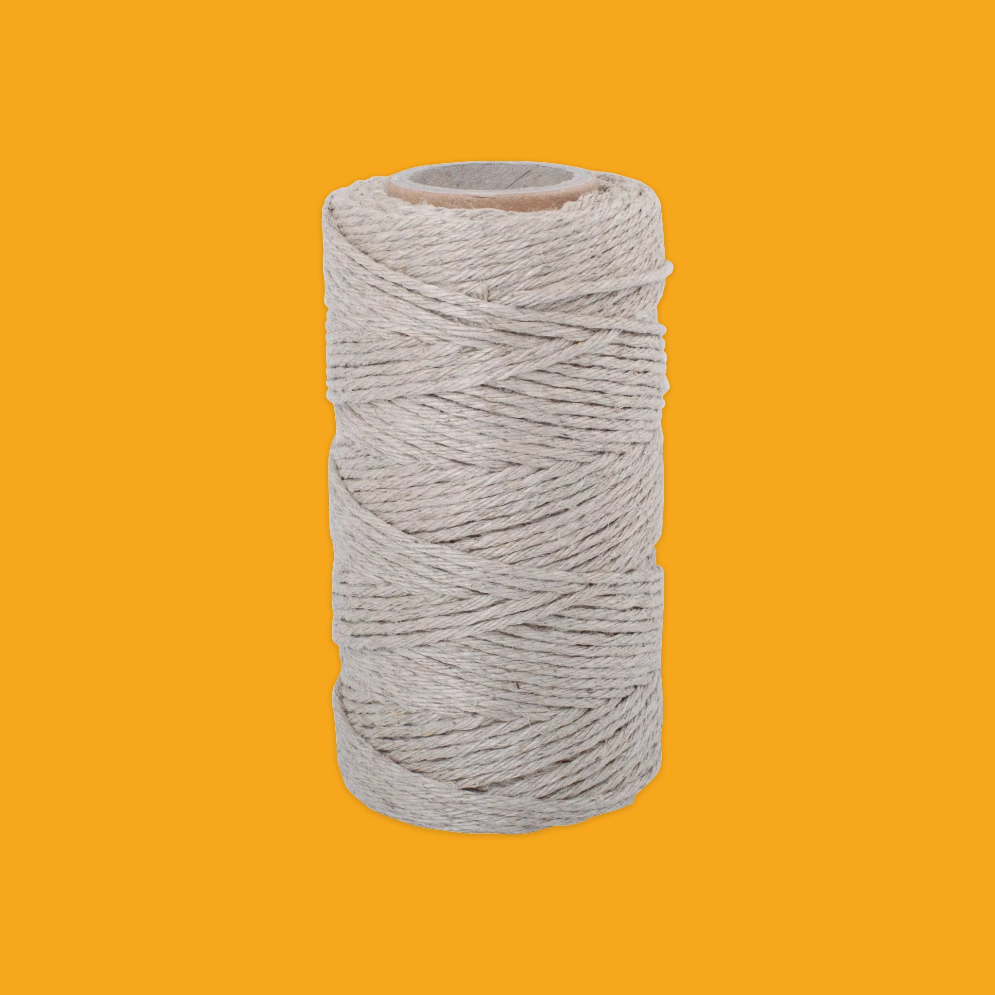 Spool of gray string on a yellow background