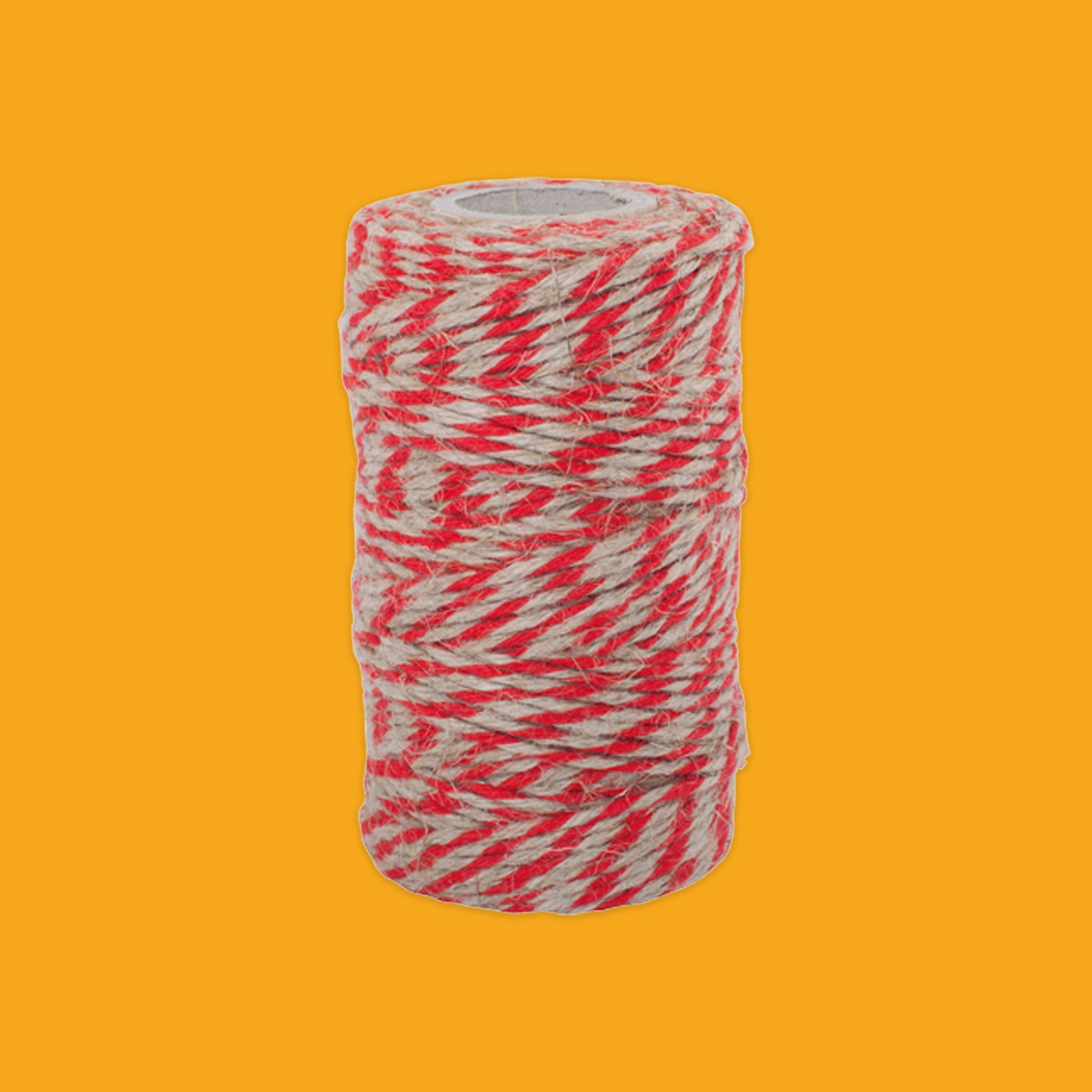 Roll of red and white twine on a yellow background