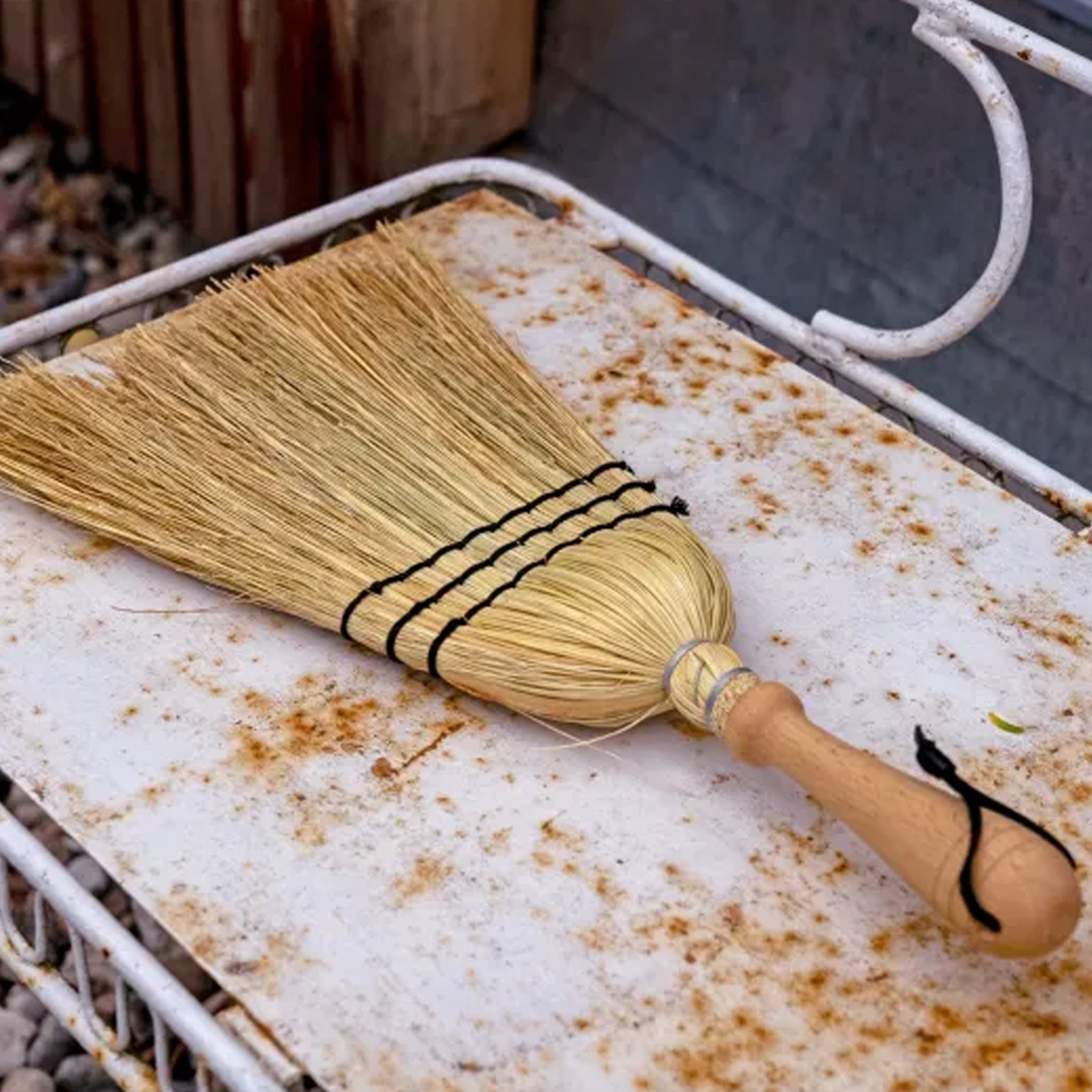 Rice Straw Hand Brush on a rusted outdoor trolley.