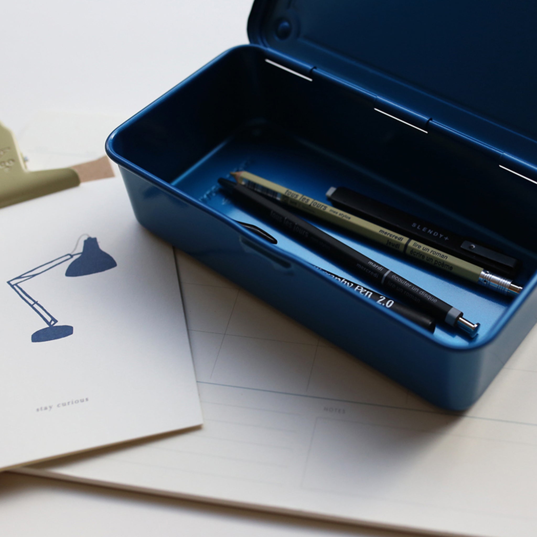 Blue box with pens on a white surface