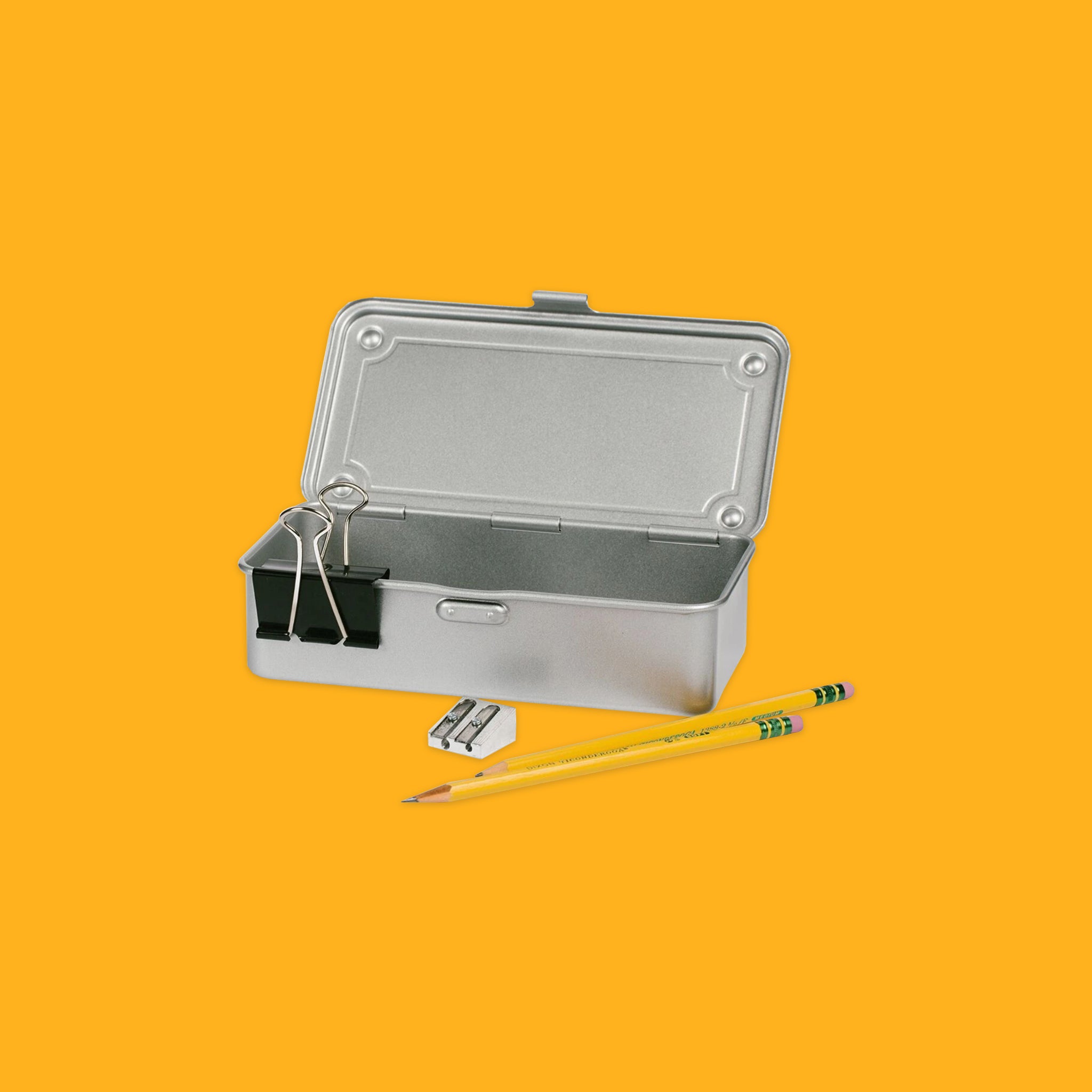 Metal box with two pencils on a yellow background