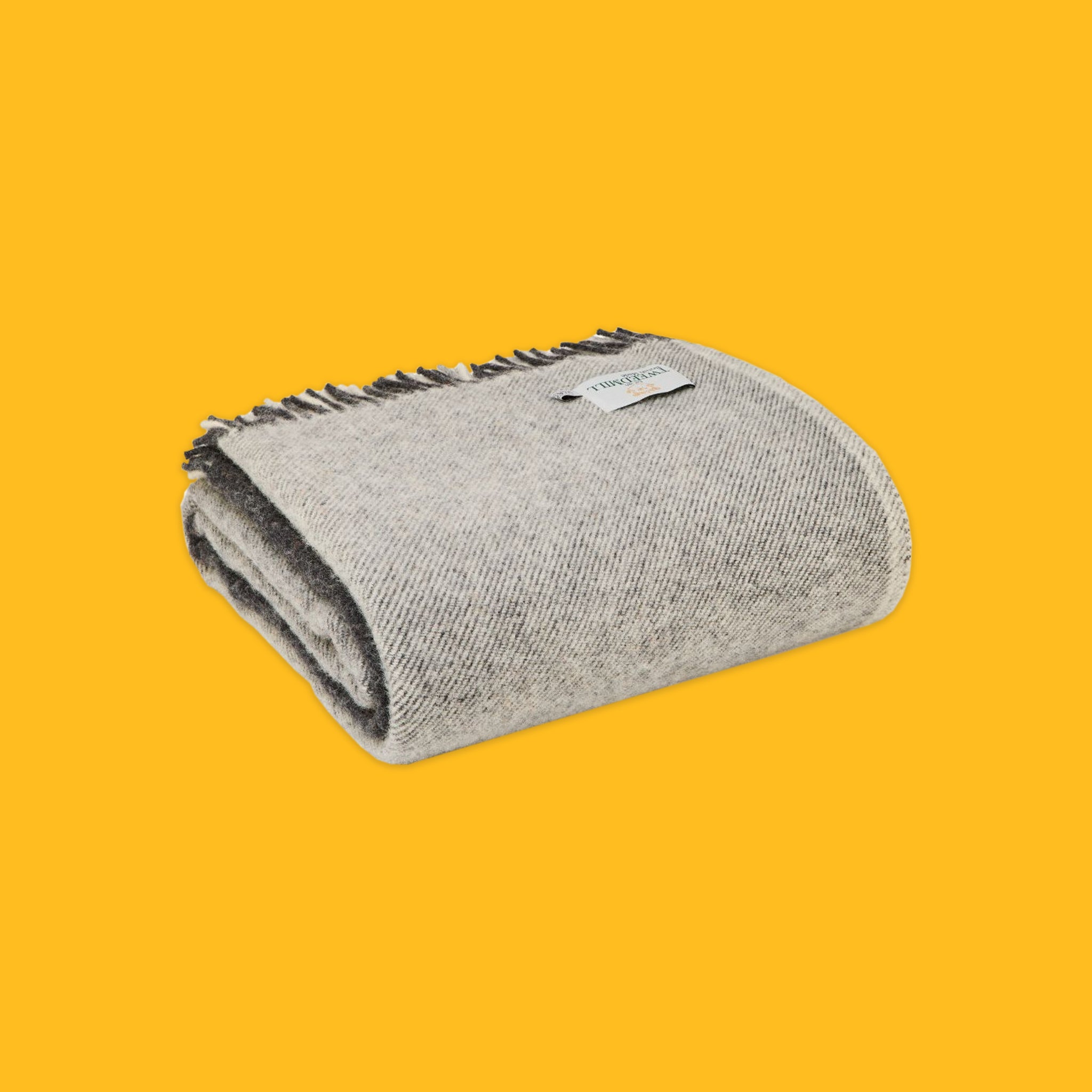 Folded Paddock Check Throw in Grey on a yellow background