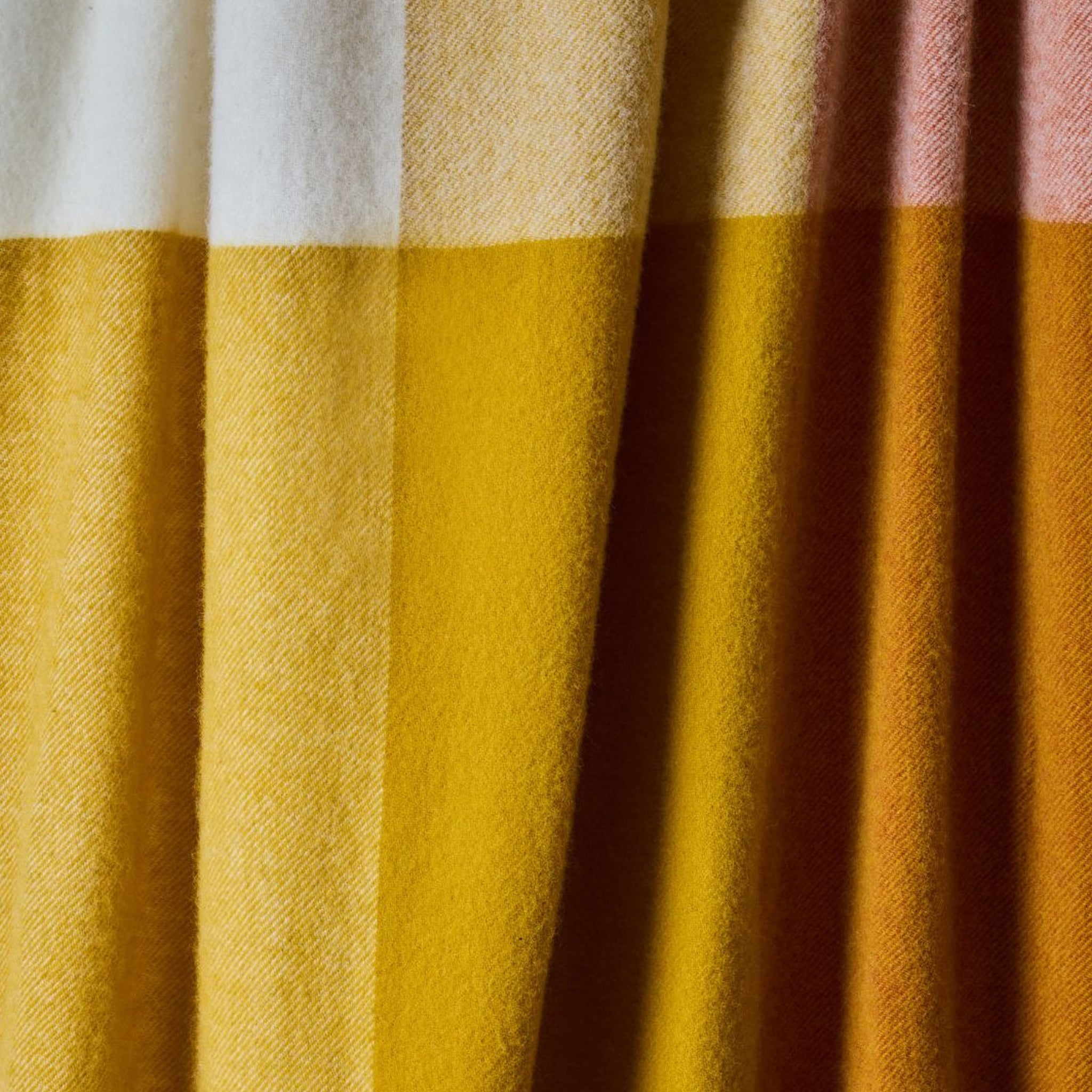Close-up of a throw with yellow, white, and pink checkered pattern