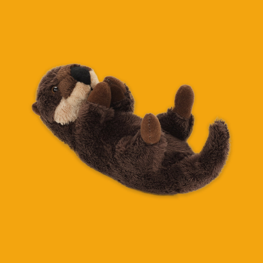 Plush toy otter on an orange background