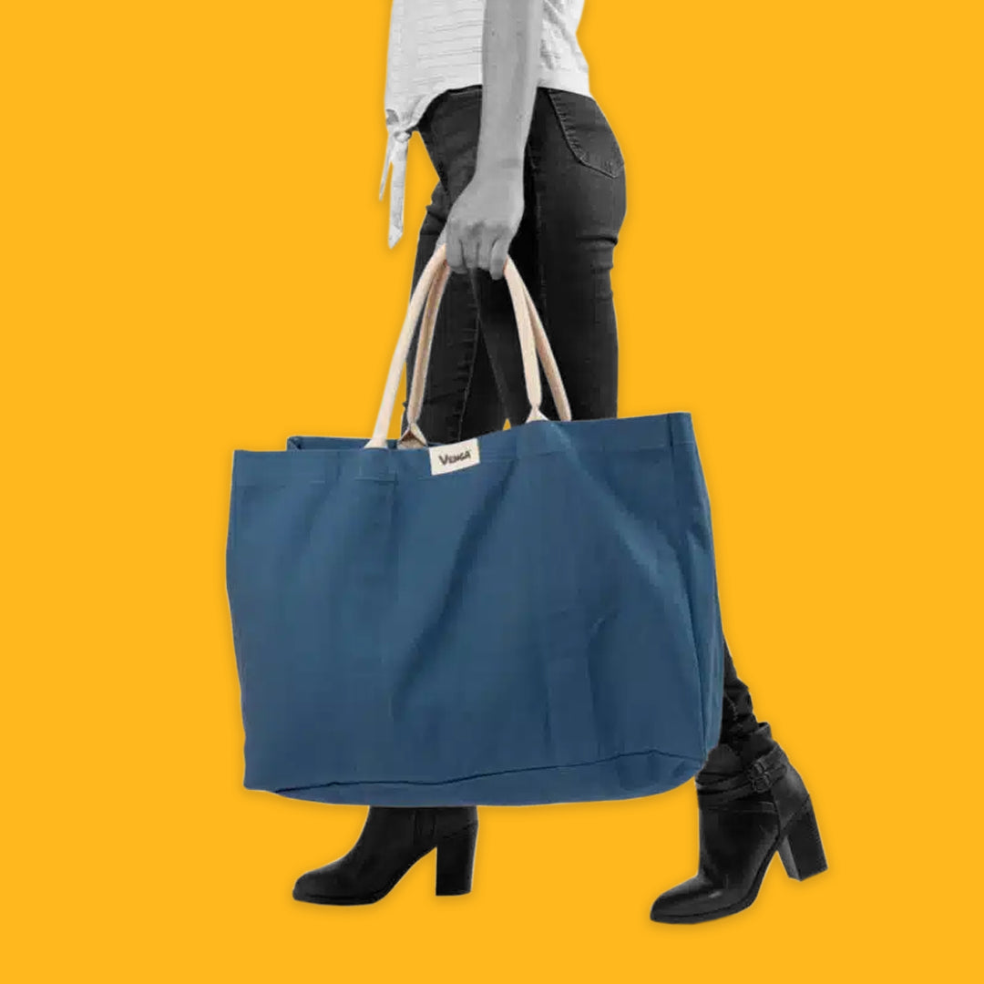 Lady carrying a blue tote on a yellow background