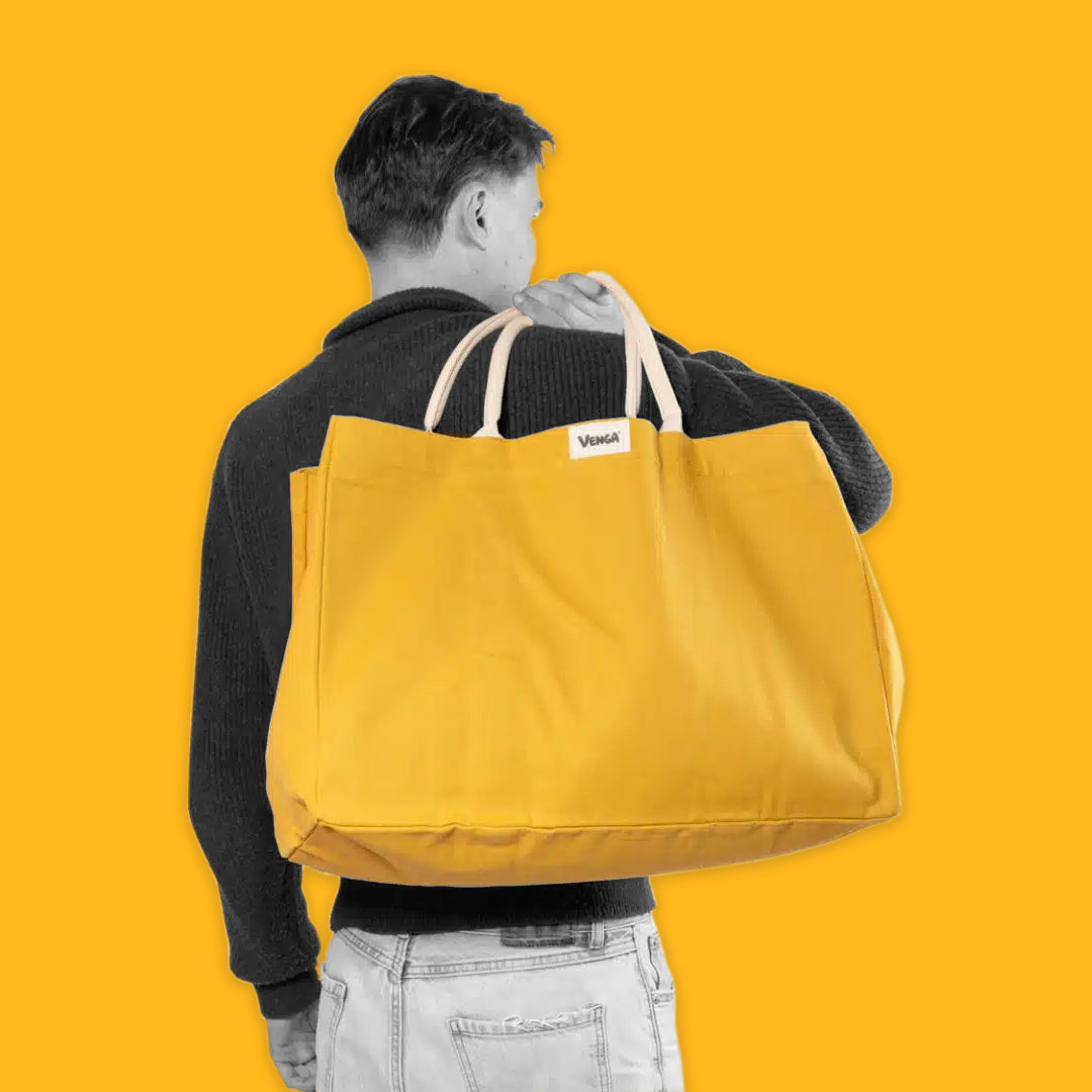 Man carrying a yellow tote on a yellow background