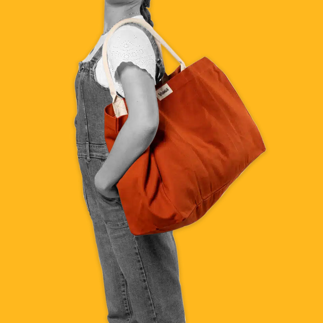 Lady carrying a red tote on a yellow background
