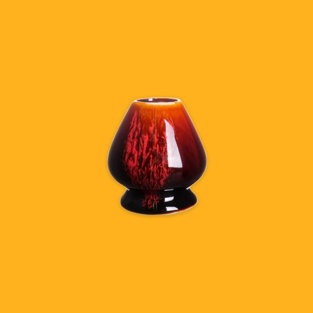 Red and Black porcelain whisk holder on a yellow background
