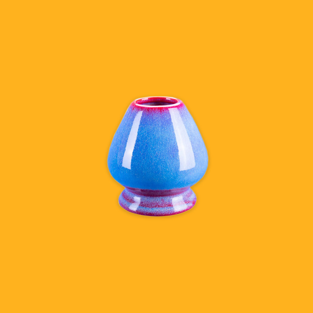 Red and Blue porcelain whisk holder on a yellow background