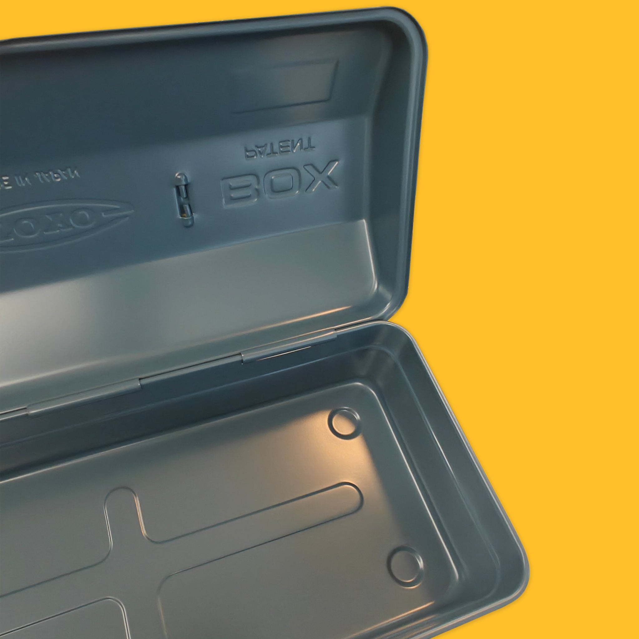 Open slate toolbox on yellow background
