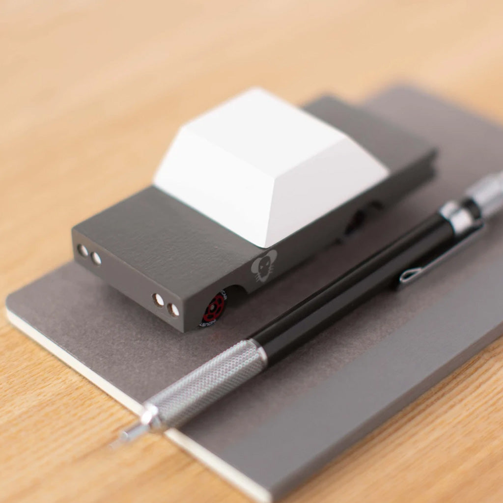 Candylab Suburbia Mouse Rod on a notepad with a pen beside it