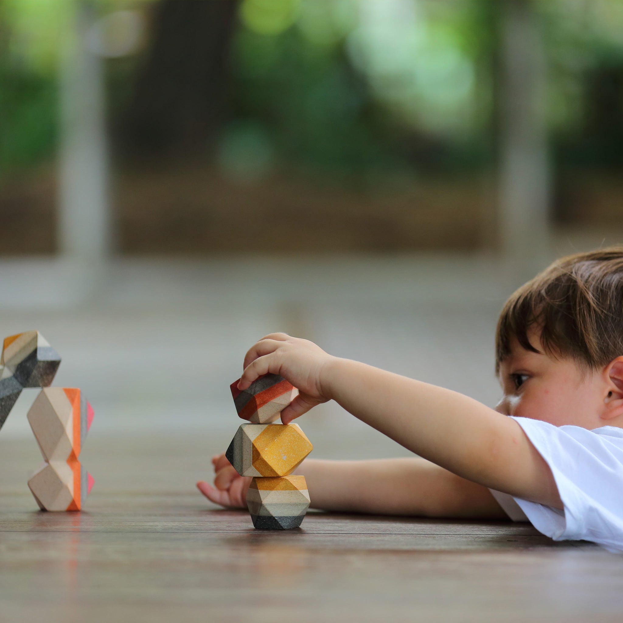 Child playing with Geo Stacking Rocks from Plan Toys