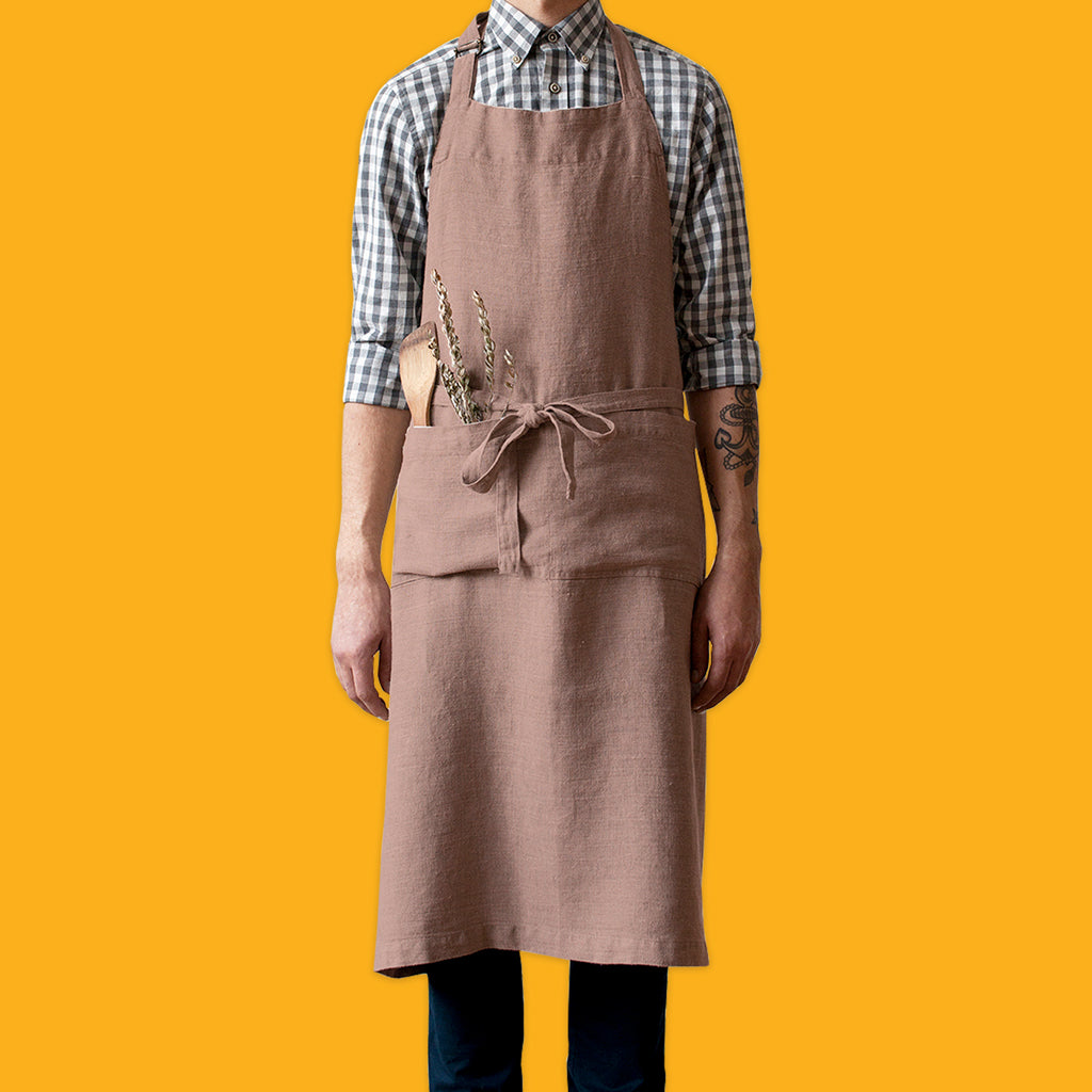 Man in check shirt wearing the Ashes of Roses Washed Linen Chef Apron by Linen Tales