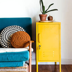 Mustard Made The Shorty in Mustard beside blue chair