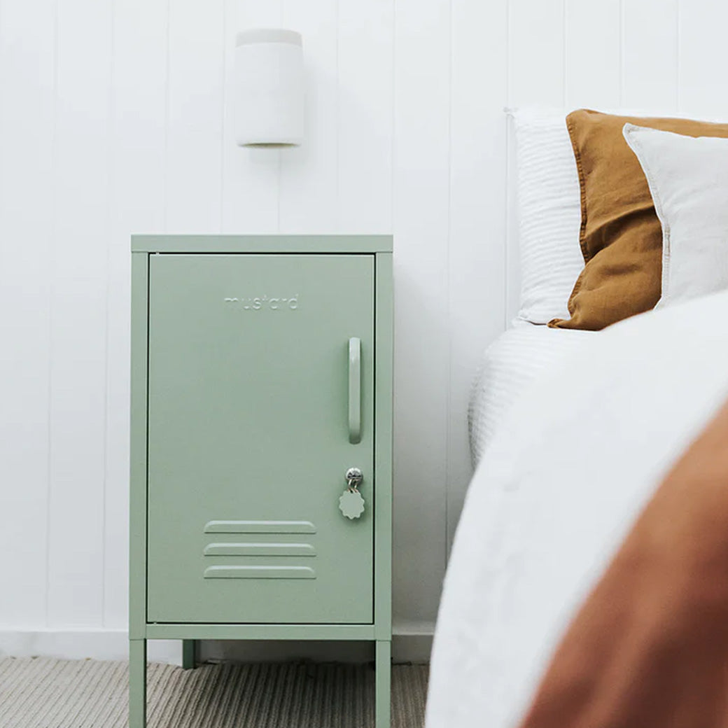 Mustard Made The Shorty in Sage beside a white bed