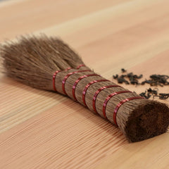 Shuro Hand Broom made from palm fibres on table