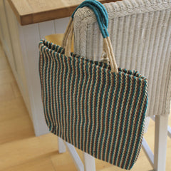 Turtle Bags Teal Striped Jute Bag Hanging on the back of a chair